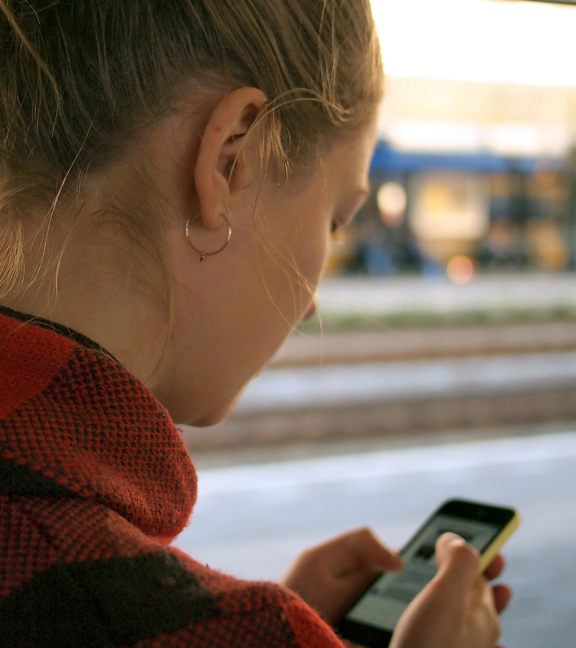 Jovem a utilizar o telemóvel para abrir conta bancária online, com ambiente descontraído e moderno.