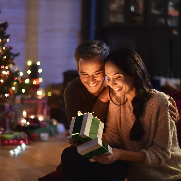 Casal em casa num ambiente de Natal