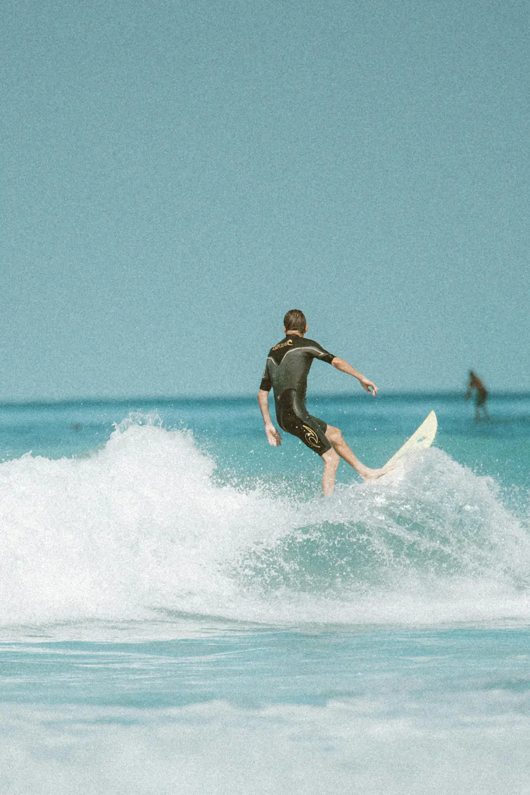 Surfista a aproveitar uma onda, representando a vantagem dos baixos custos dos ETFs.