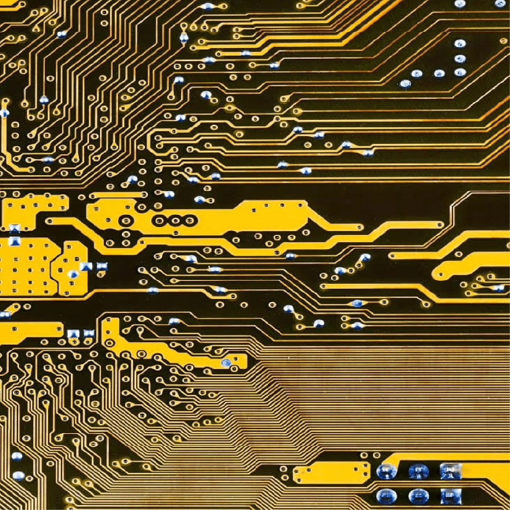 Placa de circuito eletrónico com traços dourados e pontos de solda azuis em destaque.