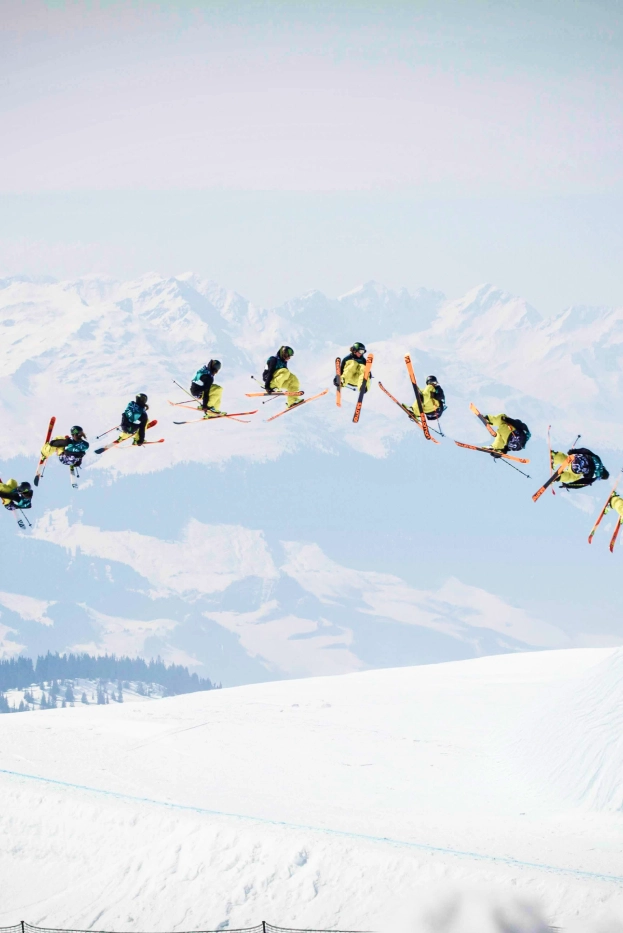 Sequência de imagens a captar um esquiador a realizar um salto acrobático sobre a neve, com montanhas cobertas de neve ao fundo, ilustrando técnica, precisão e dinamismo nos desportos de inverno.