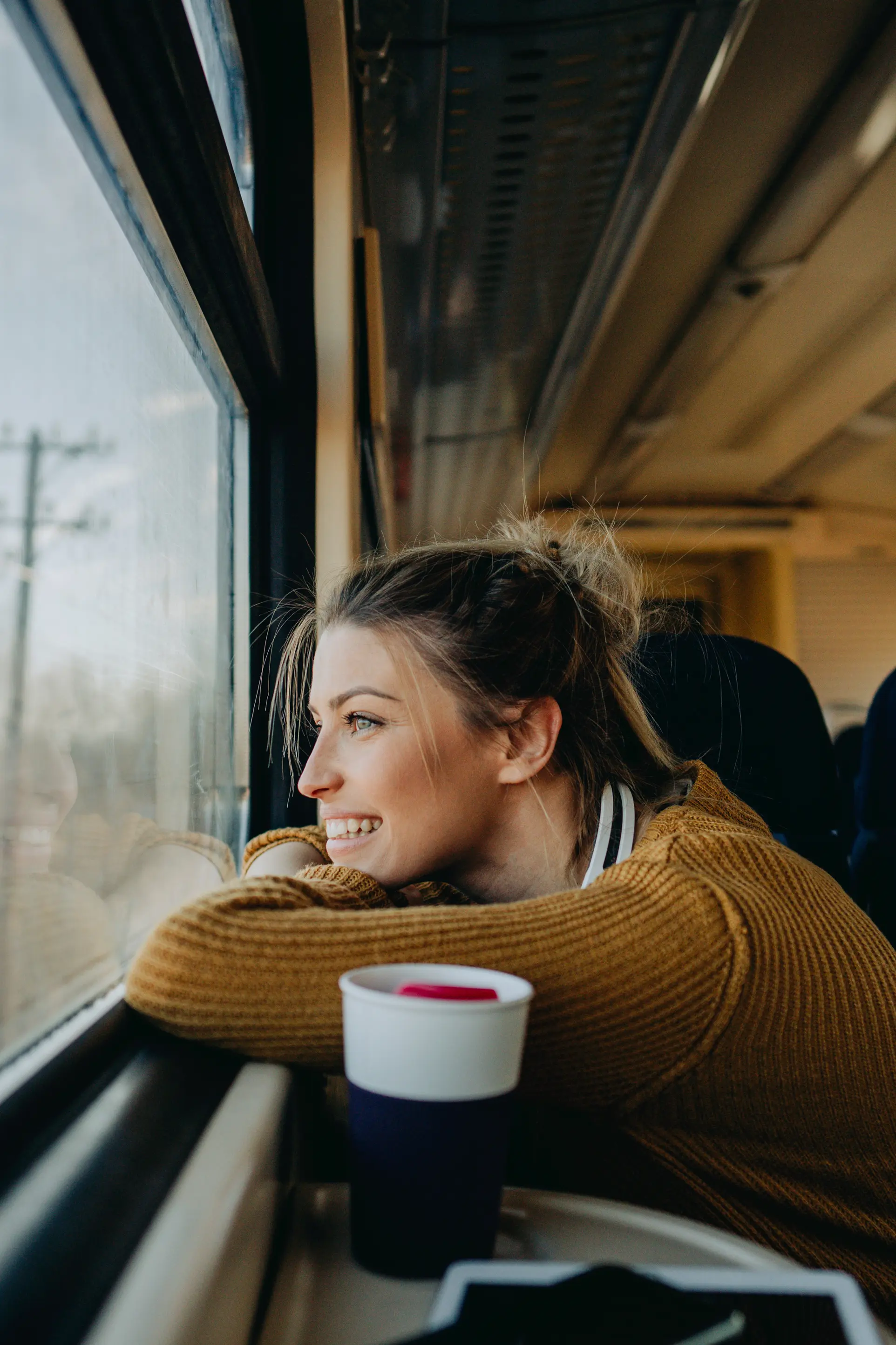 jovem investidora a relaxar durante uma viagem de comboio, simbolizando a liberdade de acompanhar os investimentos em qualquer lugar com a NextGen.