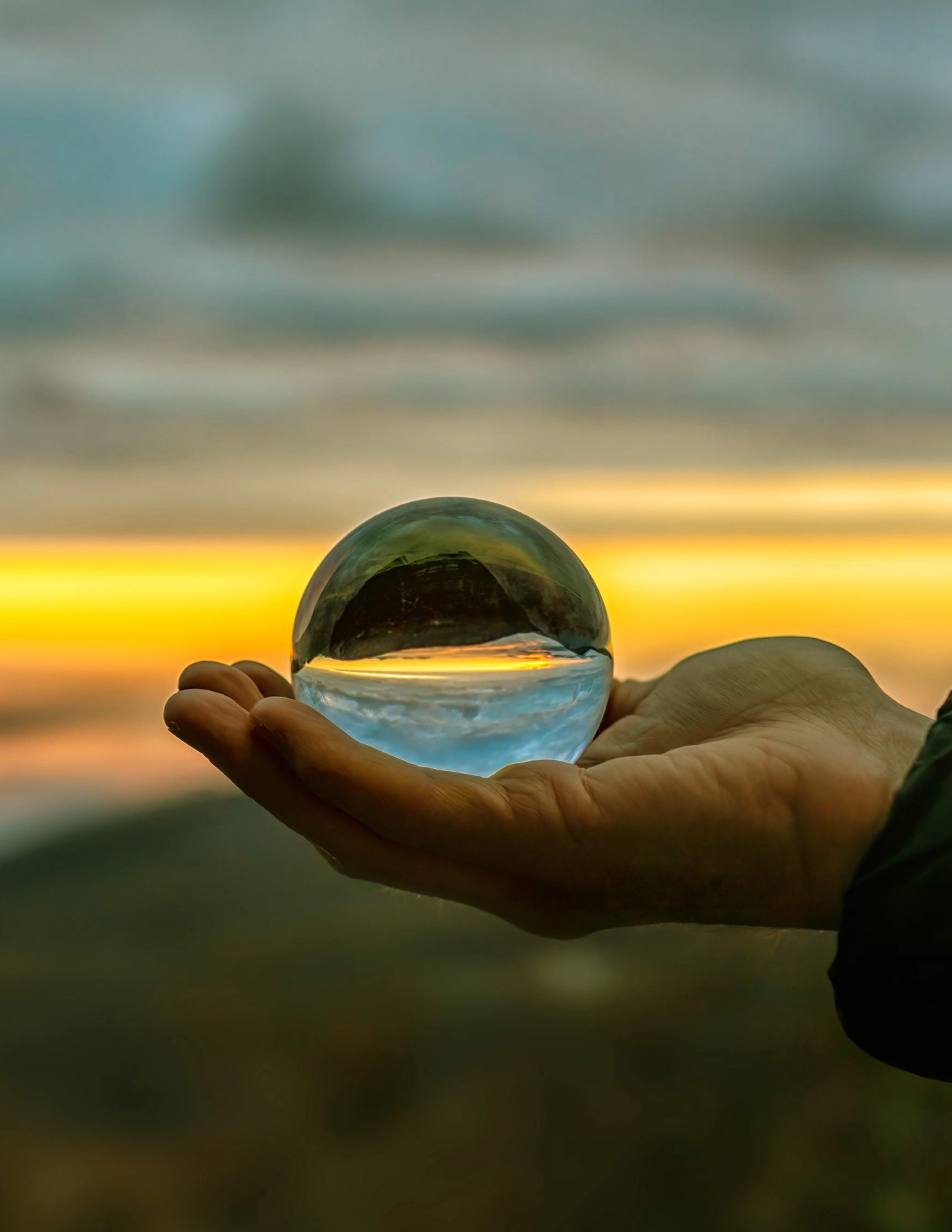 Plano aproximado de uma mão a segurar numa bola de cristal