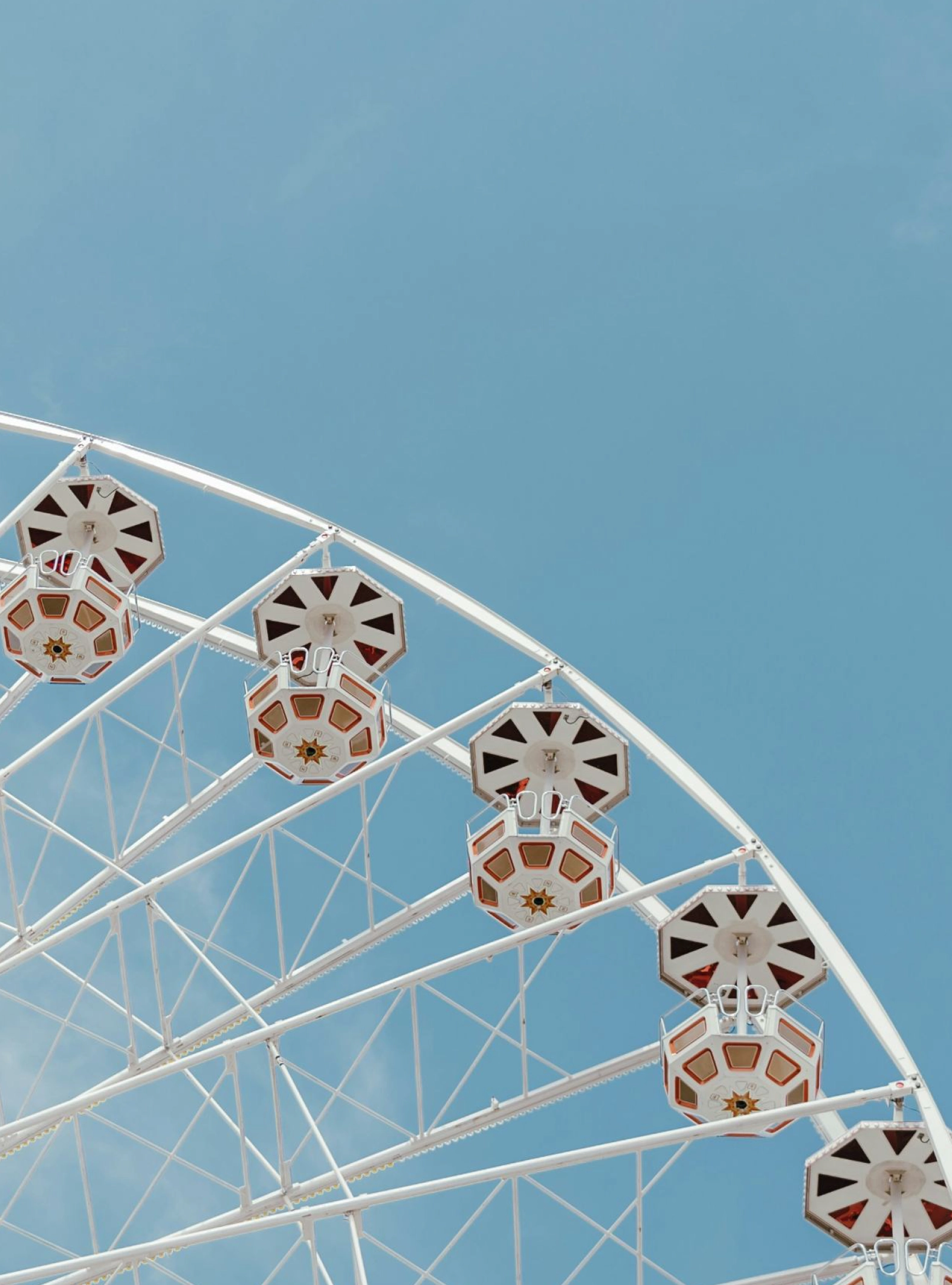 Plano de uma roda gigante, com fundo de céu limpo. Uma atmosfera agradável de parque de diversões.