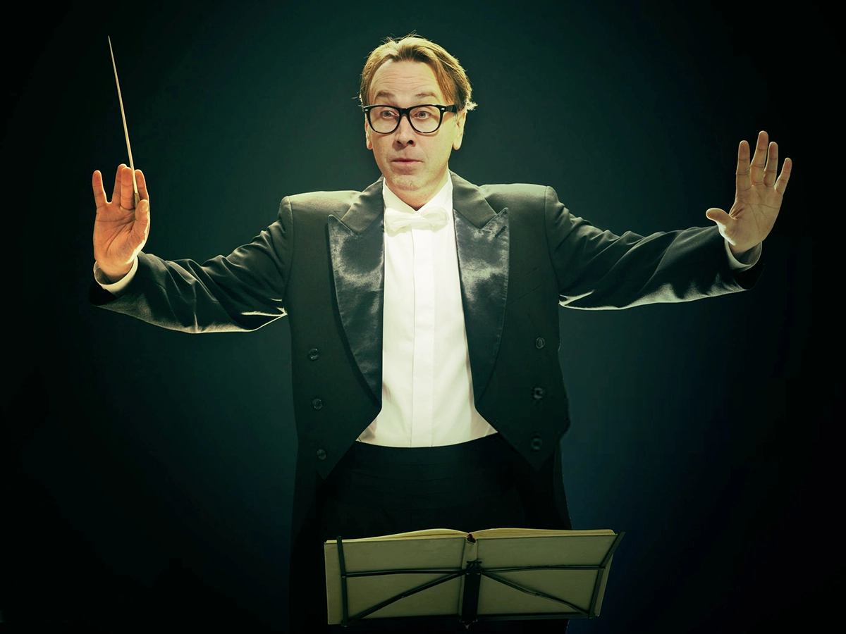 Maestro a iniciar a orientação da orquestra, simbolizando o Unit-Linked Adagio