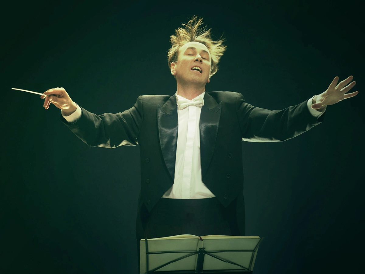 Maestro a orientar intensamente a orquestra, simbolizando o Unit-Linked Allegro