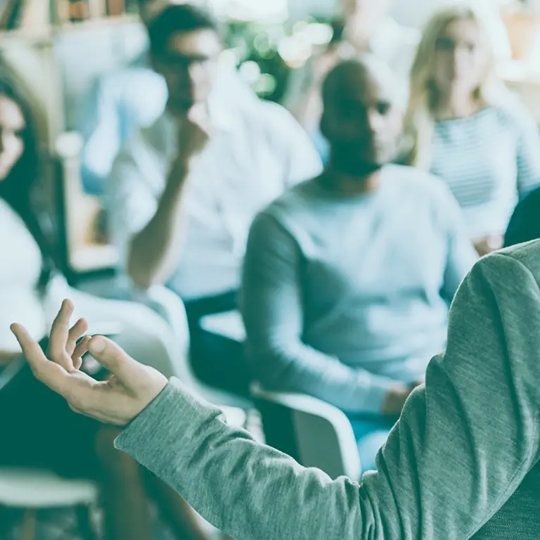 Person giving a lecture to an audience, symbolizing the Banco Carregosa Academy and its commitment to raising financial literacy in Portugal